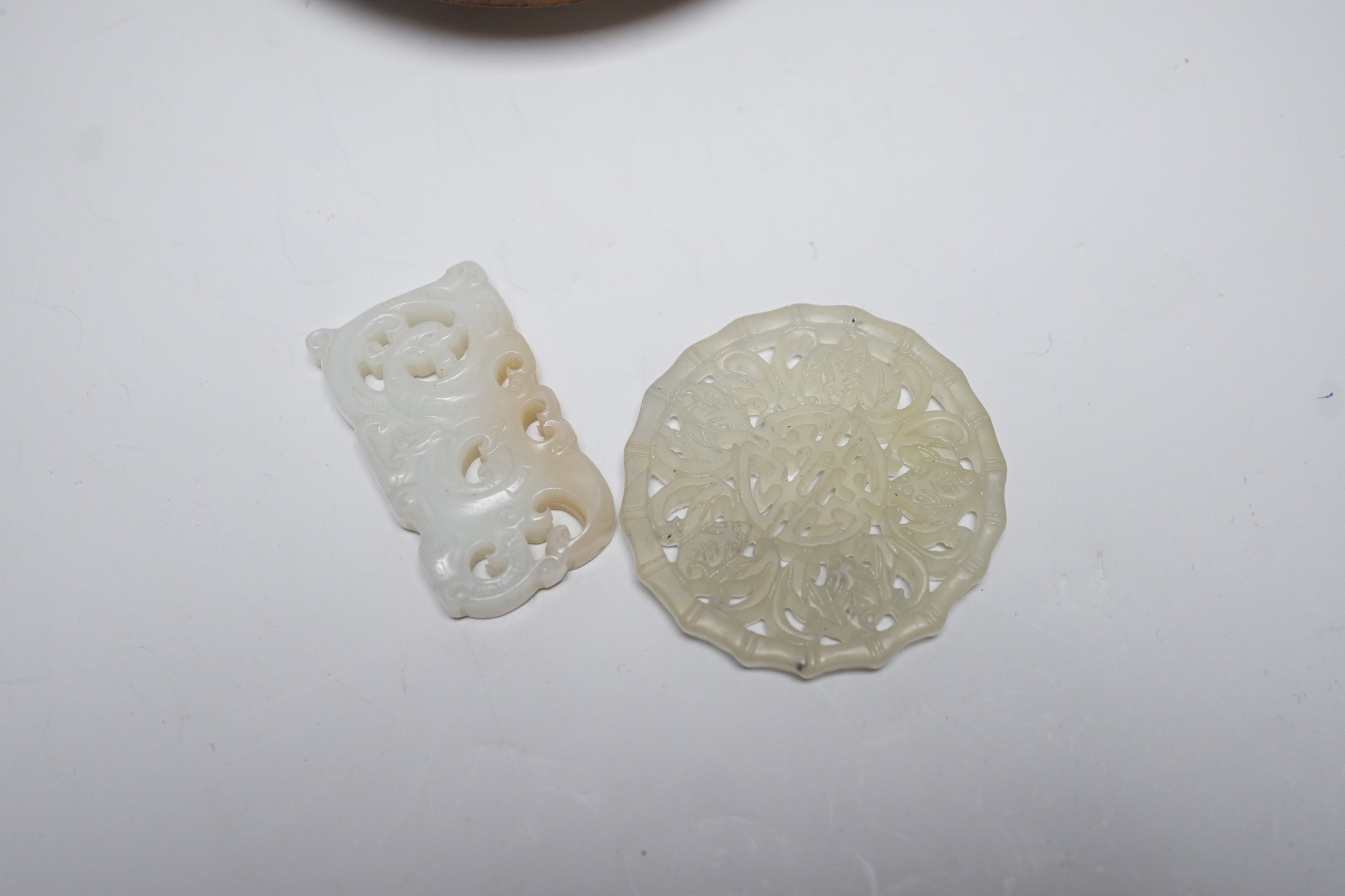 A Chinese pale celadon jade pendant, 4.6cm, a bowenite jade disc and a Canton enamel dish